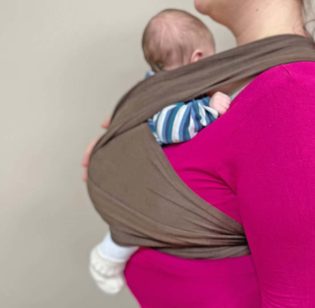 Tragesystem mit Baby auf der Schulter, Elternbereich, Familienbetrieb, Hebammenpraxis, Unterstützung.